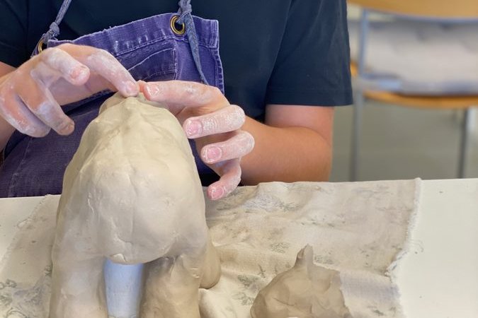 Barn formgiver en keramisk skulptur